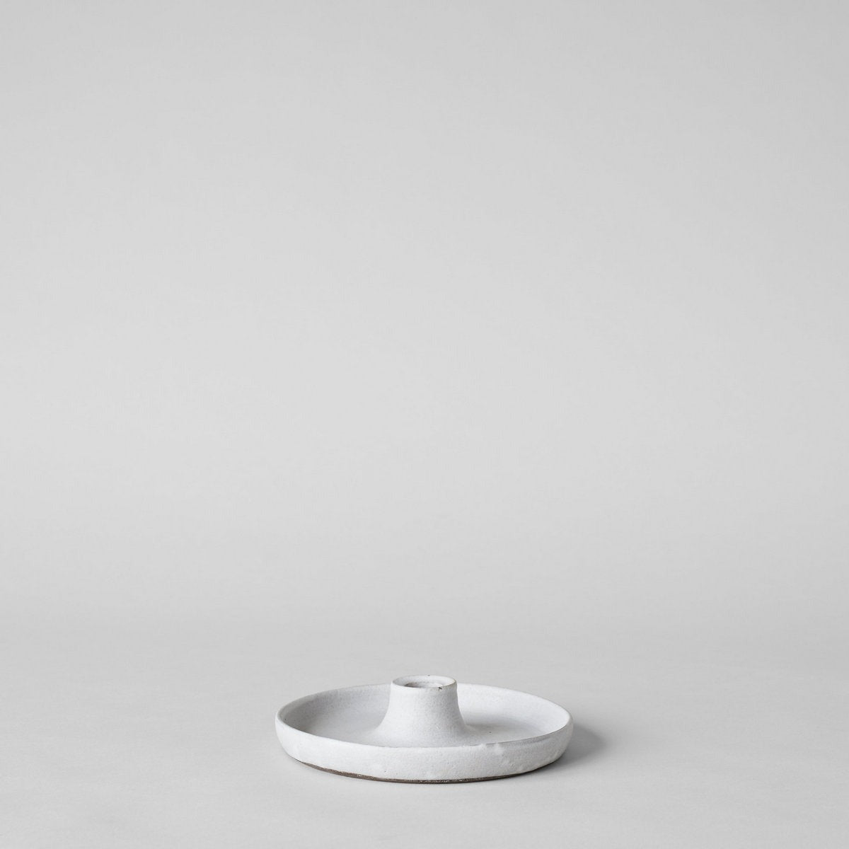 Artisan stoneware taper holder crafted from dark clay with natural matte glaze