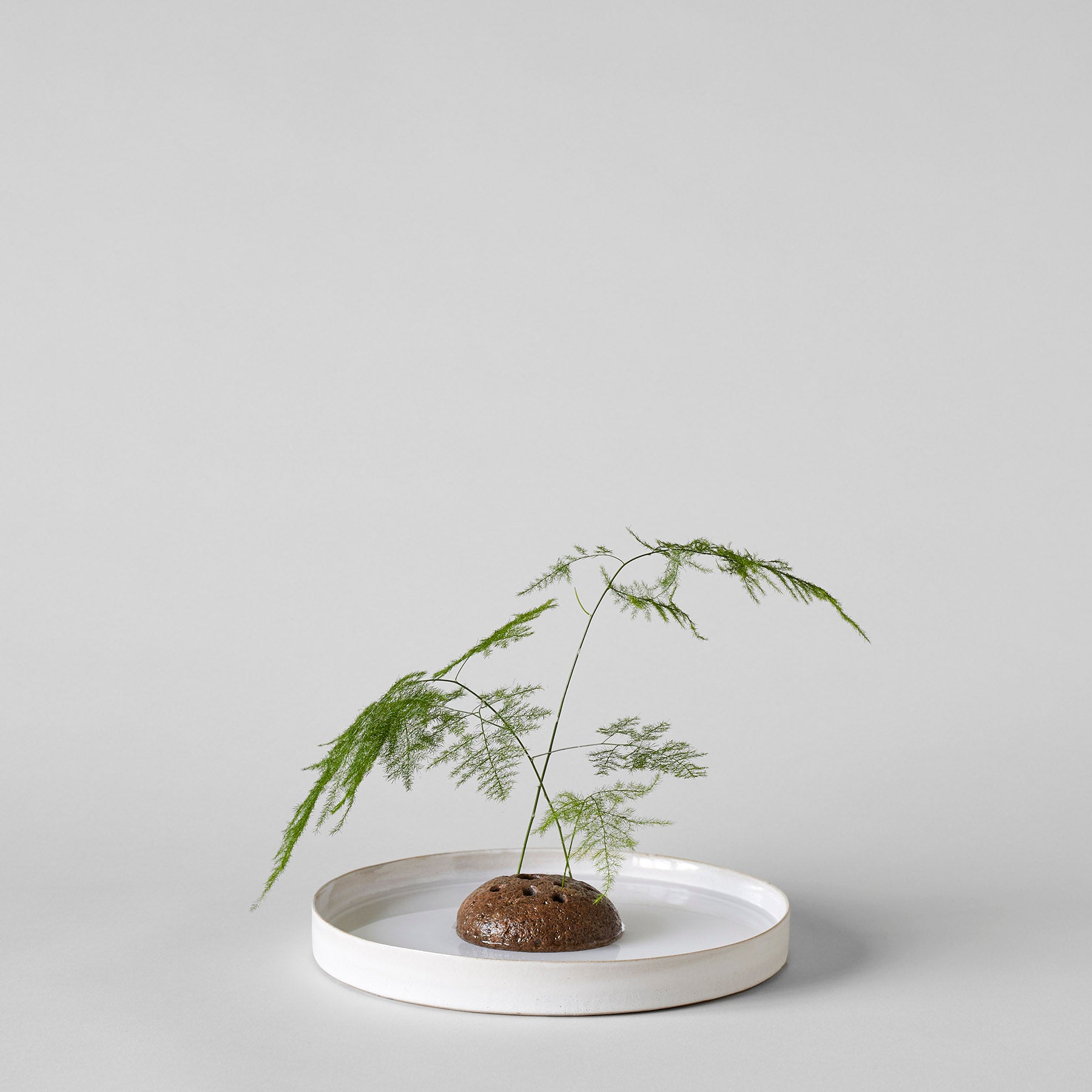 Stone flower frog used for a low, open floral arrangement on a tabletop