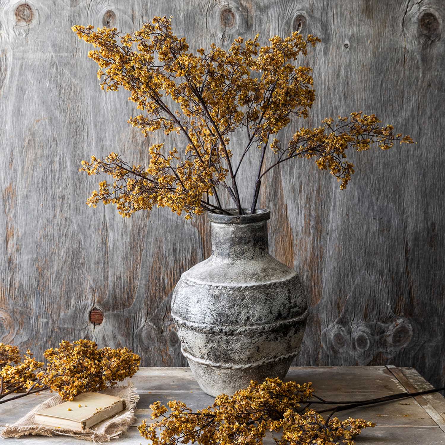 Artificial Sedge, Winter Saffron sedge grass stem with branching brown stems and clusters of small saffron-colored seed heads displayed in a weathered ceramic vase.