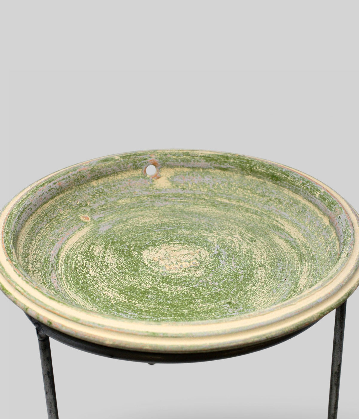 Close-up of Bloomist x NYBG Garden Sage terracotta bird bath showing the shallow basin, rounded rim, drainage opening, and impressed branding