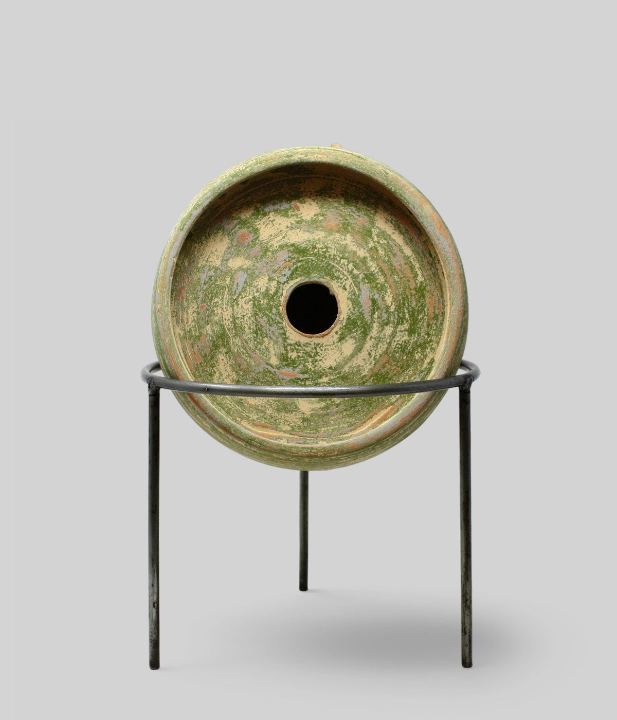 Front view of the Garden Sage terracotta birdhouse on a wrought iron stand with a circular recessed face and central entry hole