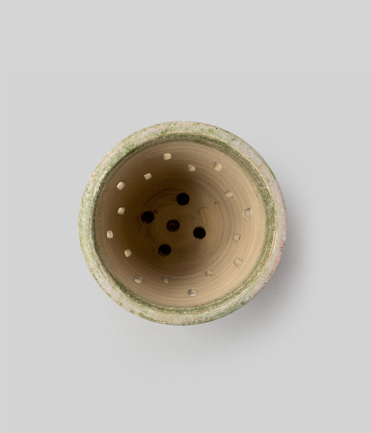 Top view inside the Garden Sage terracotta orchid pot showing multiple side openings and drainage holes at the base