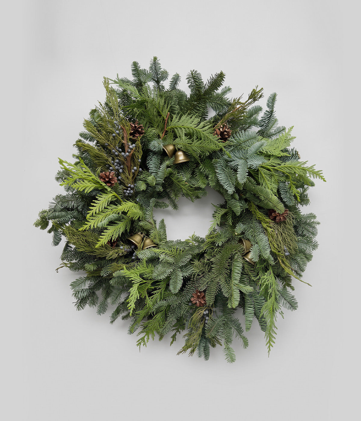 Clara Christmas wreath with bells, blue juniper berries, lodgepole pine cones, and fresh mixed evergreens
