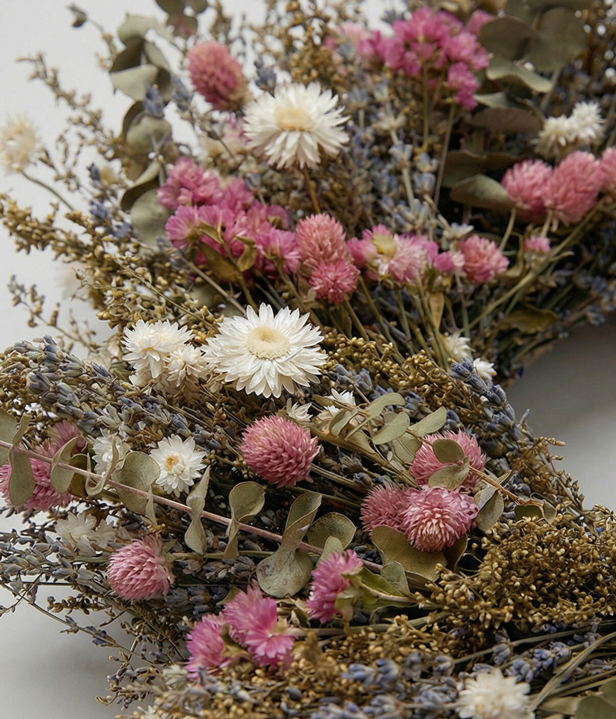 Close-up of spring floral wreath with pink statice, ivory strawflowers, lavender, baby eucalyptus