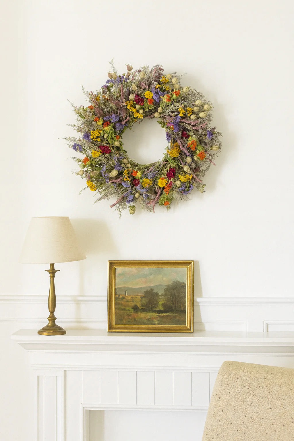Estelle colorful wreath displayed on wall above white console