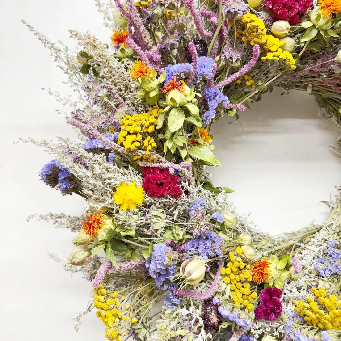 Close-up of Estelle wreath showing vibrant yellow, purple, orange, and burgundy dried blooms