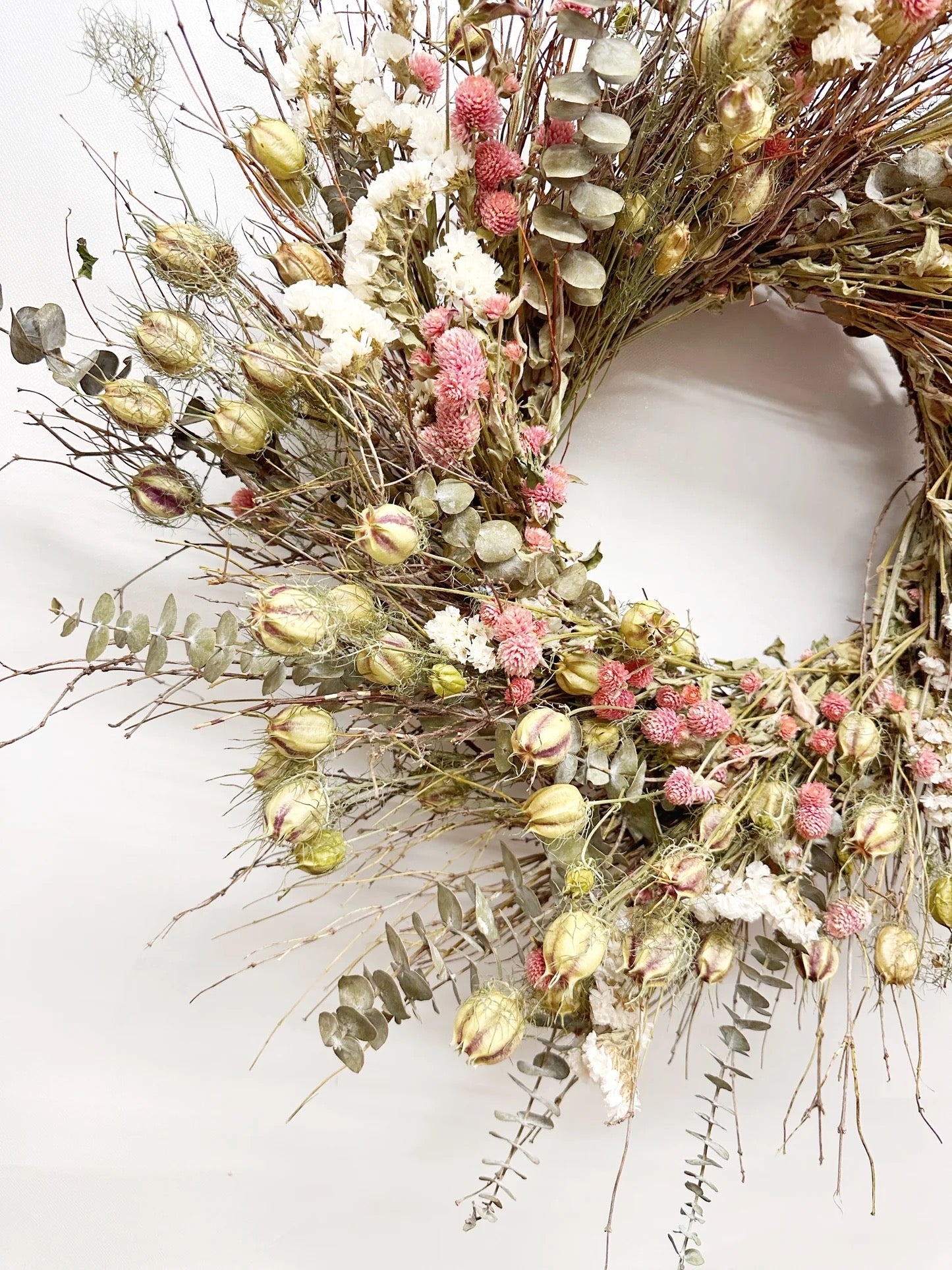 Close-up of Isabelle wreath showing quail brush twigs, eucalyptus leaves, and pink globe amaranth