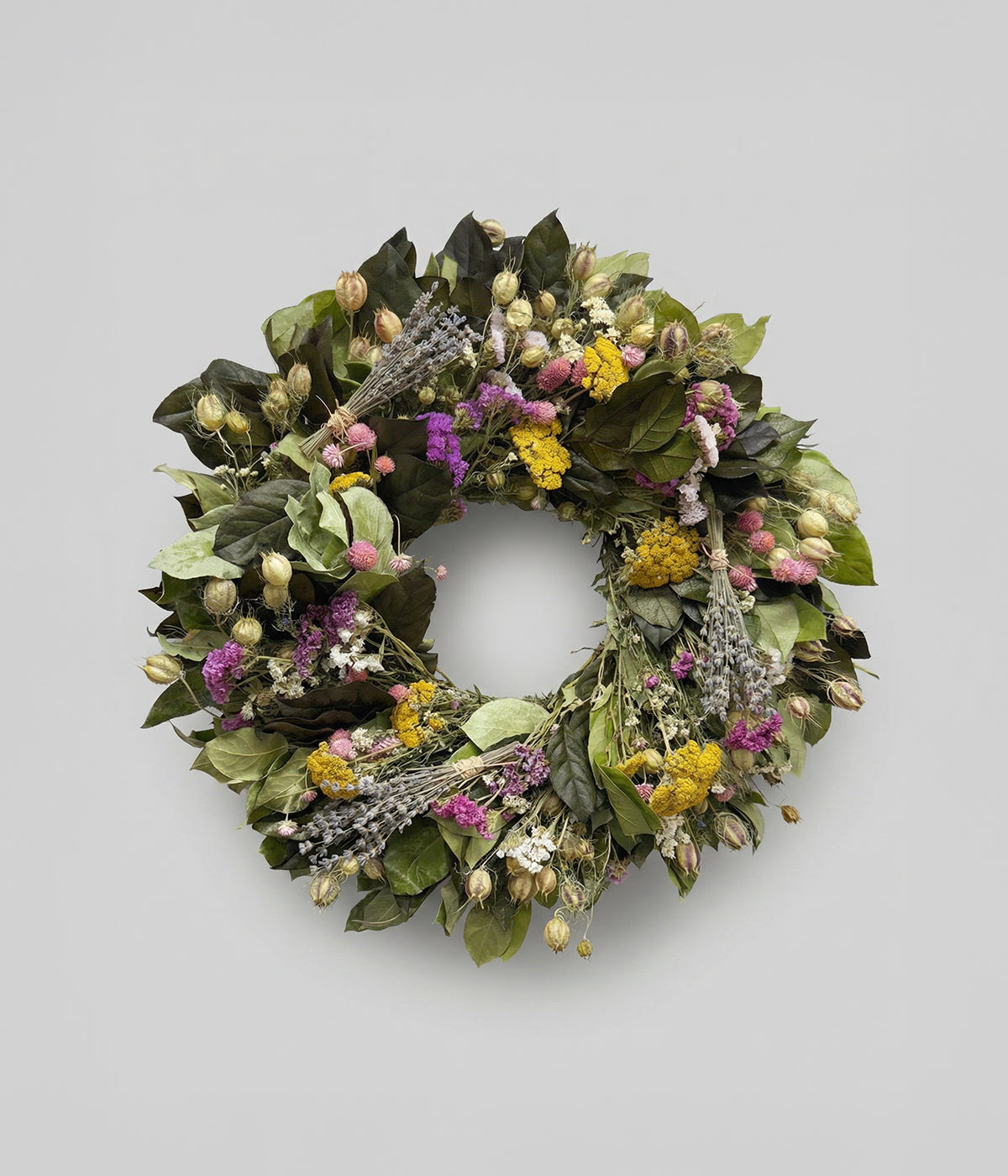 Preserved leaf wreath with dried florals on a grey background