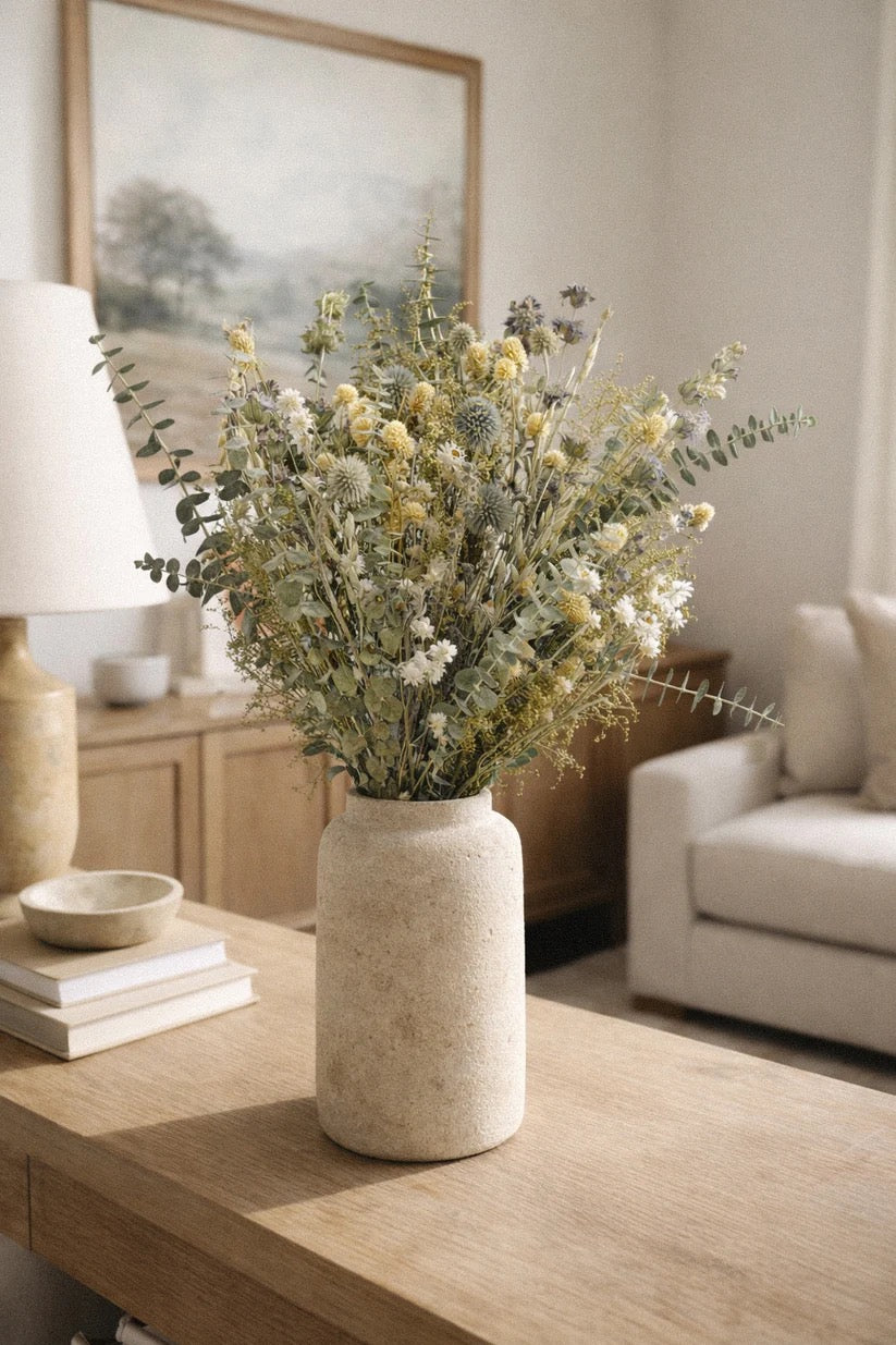 Green dried bouquet styled indoors with eucalyptus and neutral ceramic vessel
