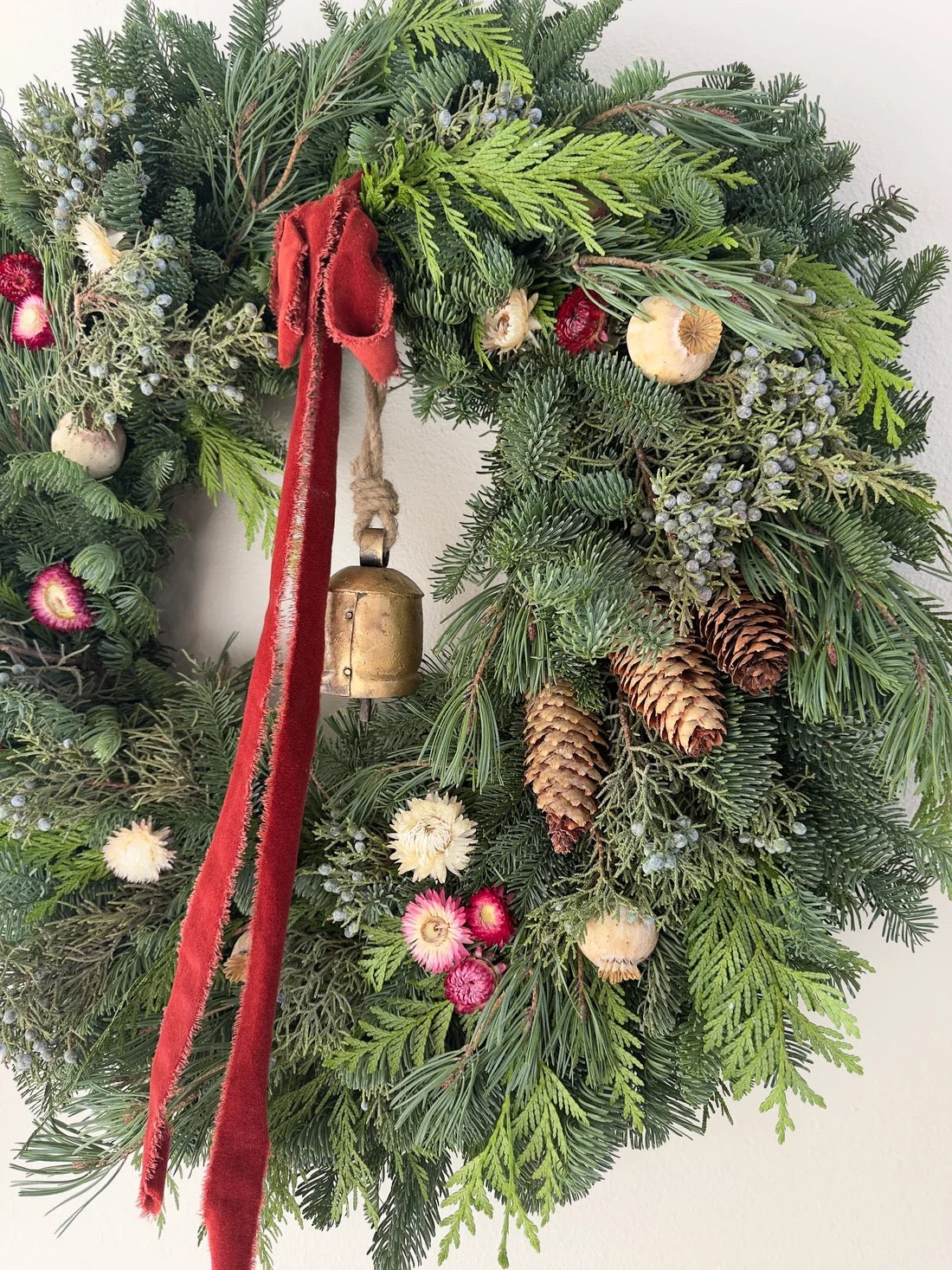 Close-up of Juliette wreath with strawflowers, poppy pods, juniper berries, and pine cones