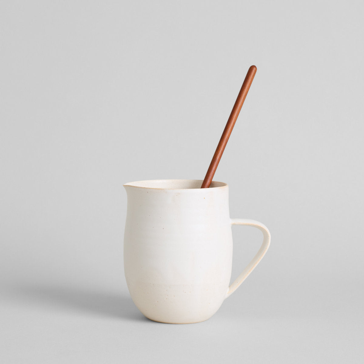 White ceramic pitcher vase with large handle for pouring or floral arrangements