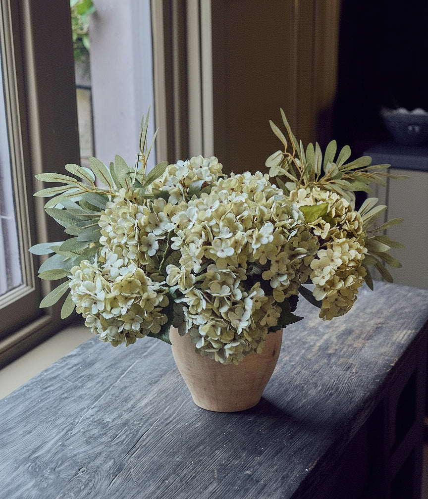 Artificial green flower arrangement with rounded hydrangea blooms and tall willow sprays