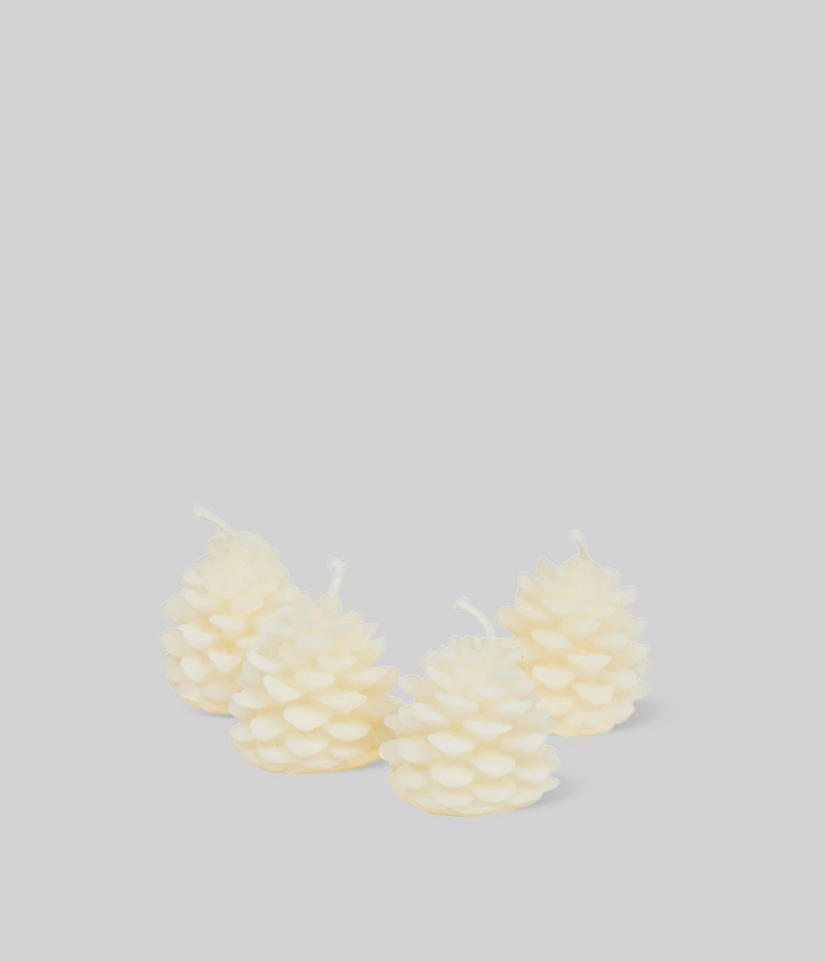 Cream beeswax pine cone candles arranged on holiday table