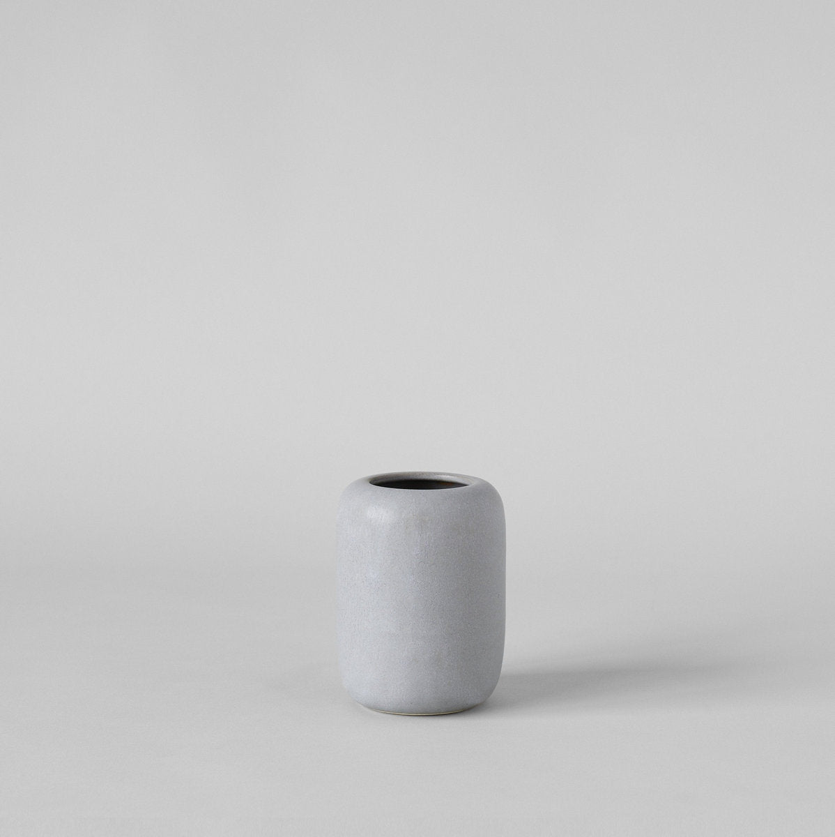 Grey ceramic vase with compact rounded form and powdery matte finish