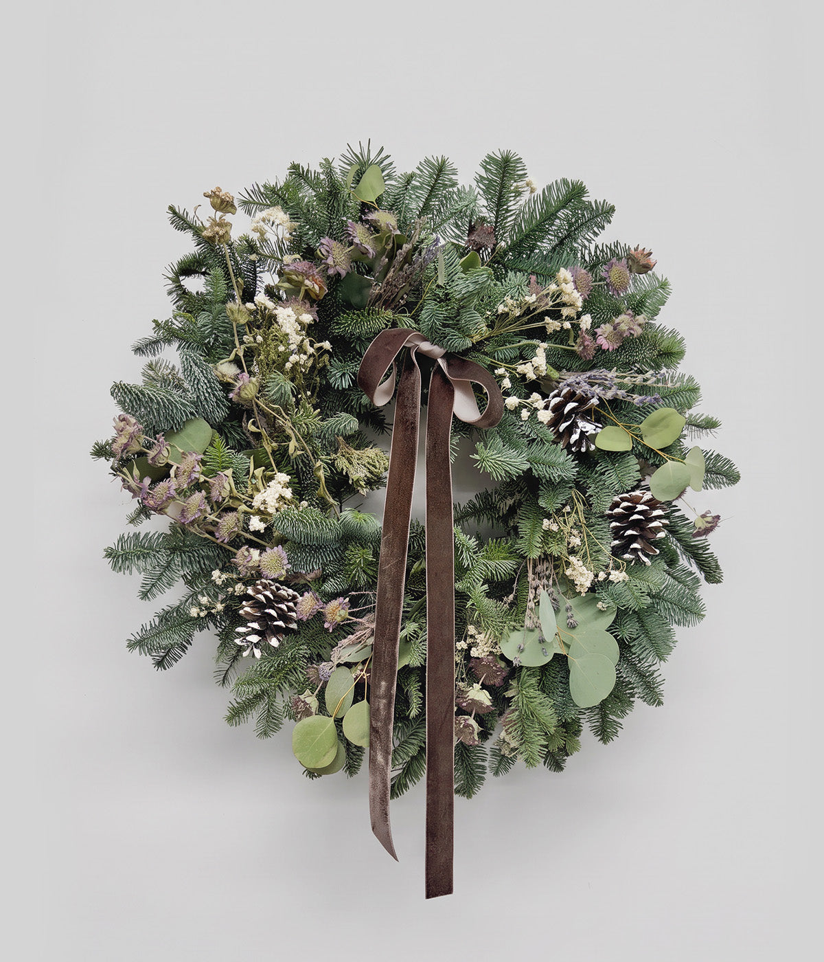 Sylvie lavender eucalyptus wreath with fresh evergreens, silver dollar eucalyptus, lavender, pine cones, and brown velvet ribbon
