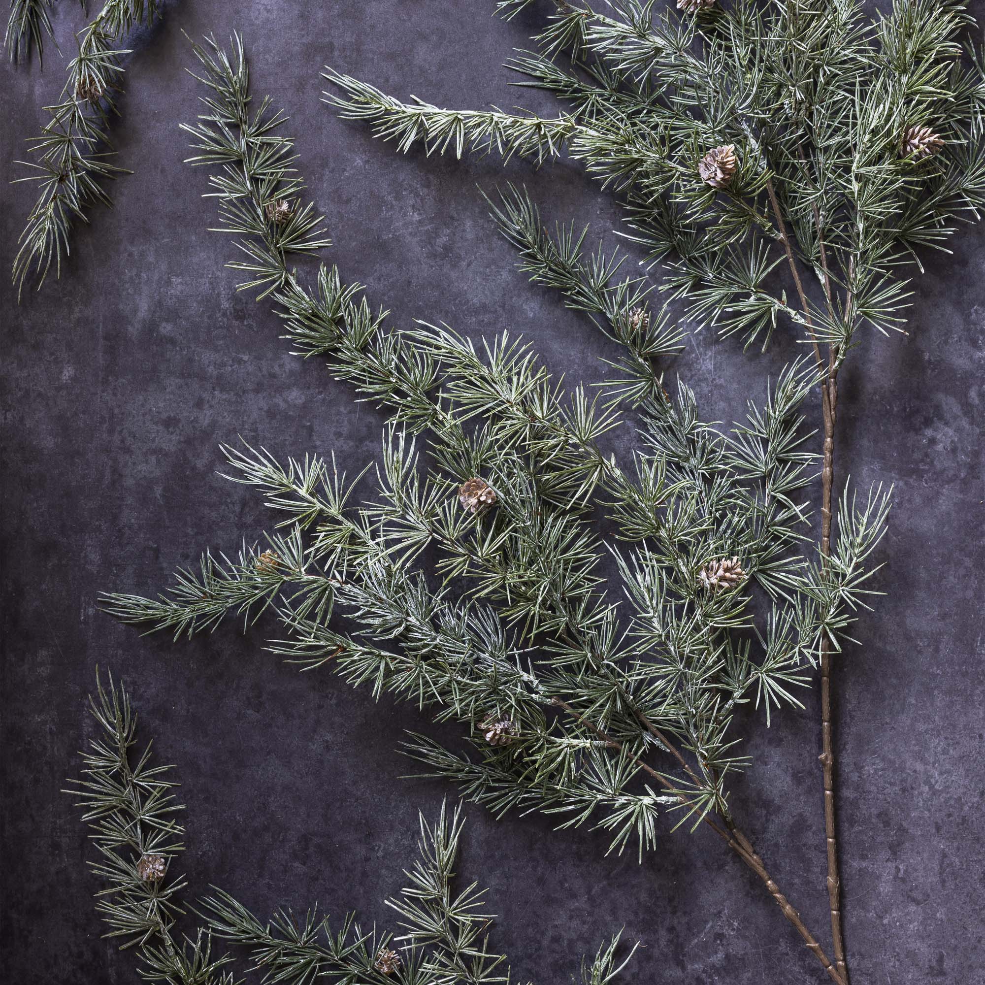 Natural-looking faux cedar and pinecone stem styled for nature-inspired interiors