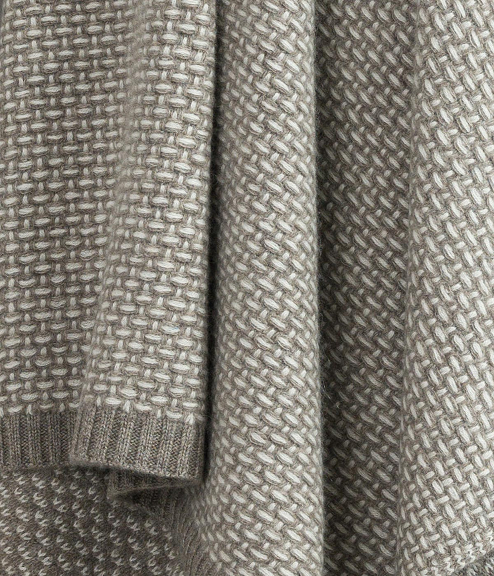 Close up of white cashmere and platinum yak fibers showcasing the fine weave and luxurious softness