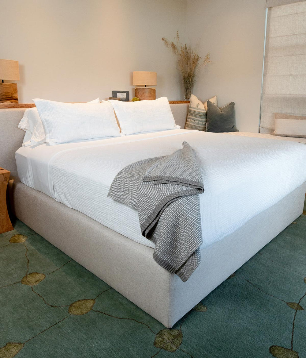 Generously sized cashmere and yak throw blanket draped on a bed adding warmth and sophistication