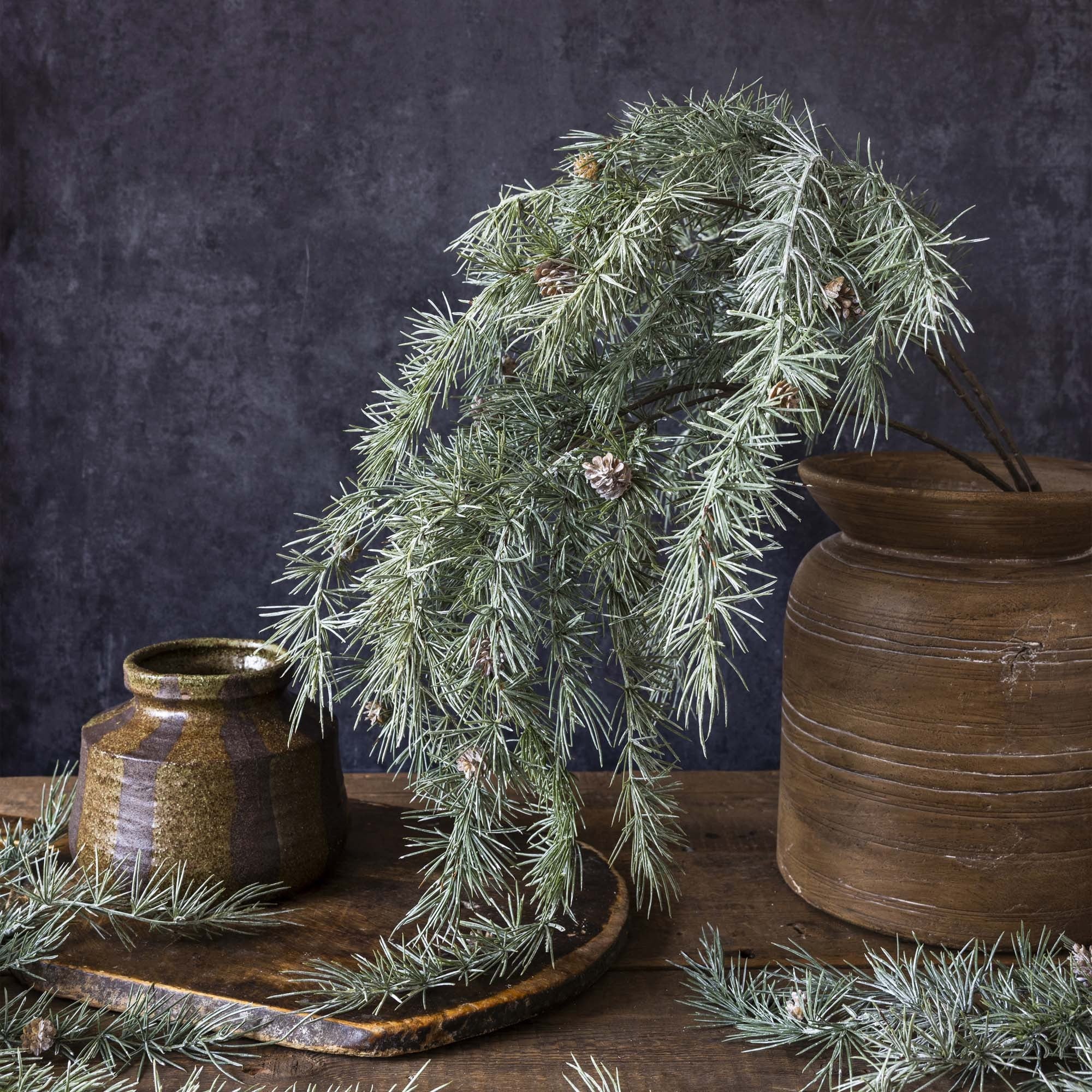 Lifelike cedar and pinecone stems adding natural texture to Christmas displays