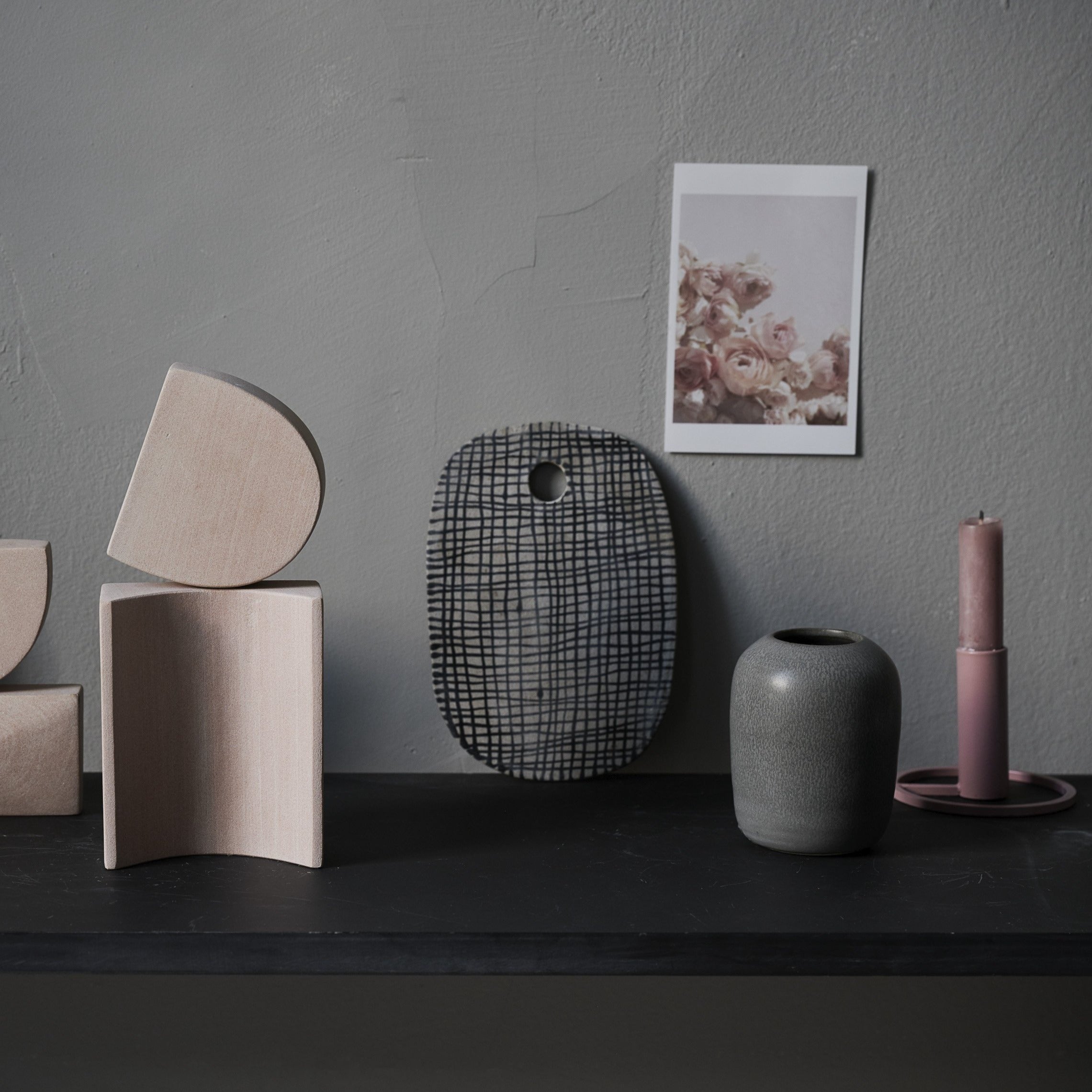 Handmade ceramic vase styled with decorative onjects on a shelf