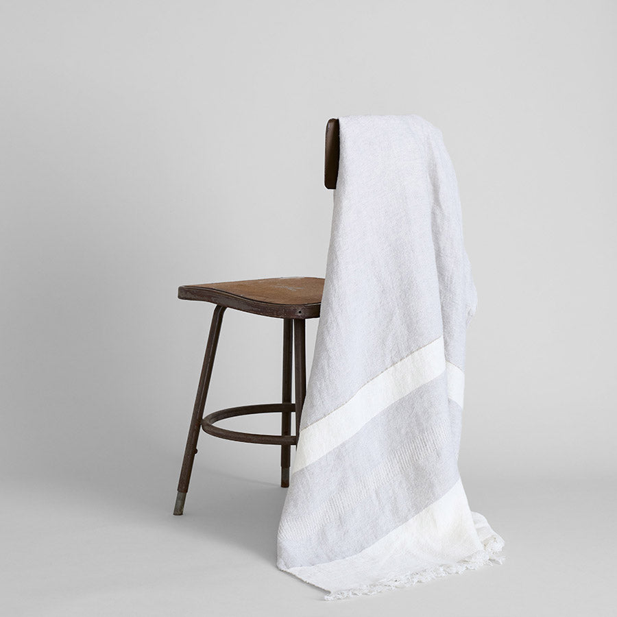 Artisan-woven Belgian linen blanket with pale grey stripes ideal for calm rustic spaces
